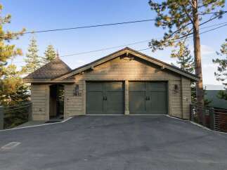 This property features a charming two-car garage with a distinctive architectural style, including shake siding and a unique turret-like entrance.