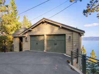 This charming property features a rustic two-car garage with classic green doors, perfect for storing vehicles and outdoor equipment.