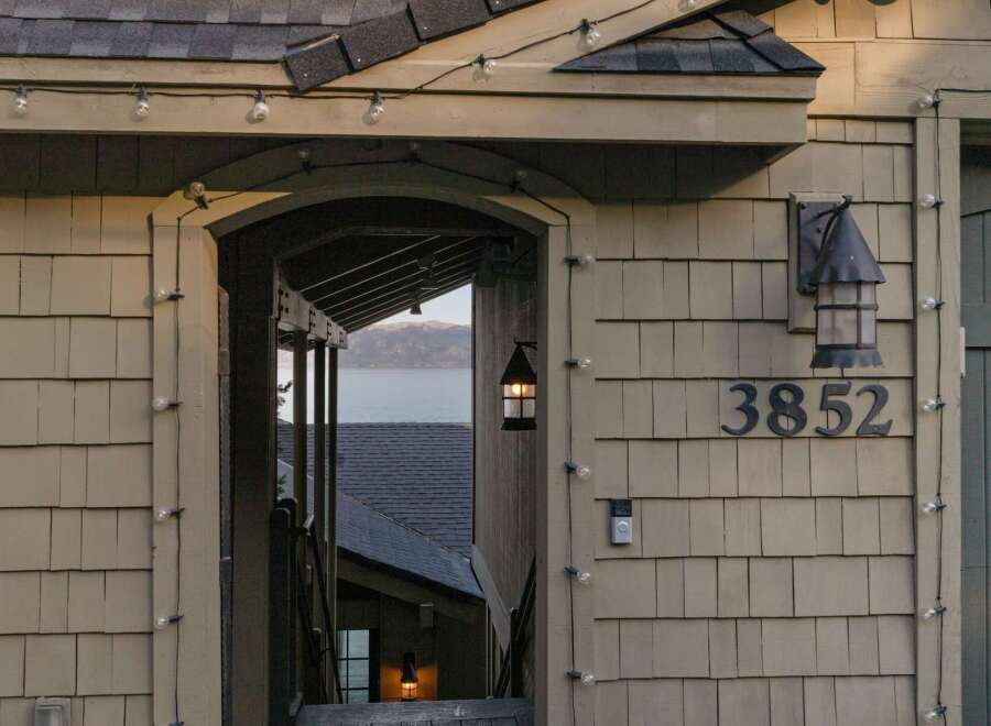 Discover this charming property featuring a welcoming entrance adorned with string lights, perfect for evening ambiance.