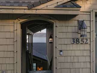 Discover this charming property featuring a welcoming entrance adorned with string lights, perfect for evening ambiance.