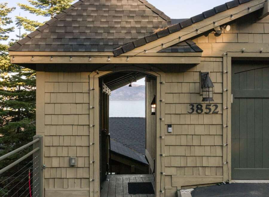 Experience breathtaking lake views from this charming property, featuring a unique architectural design with a copper-topped turret and shingle siding.