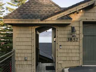 Experience breathtaking lake views from this charming property, featuring a unique architectural design with a copper-topped turret and shingle siding.