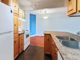 This kitchen features a white Samsung refrigerator and a white electric stove, complemented by warm wooden cabinetry.