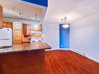 This spacious kitchen and dining area features warm wooden cabinetry and a sleek countertop, perfect for meal preparation and casual dining.