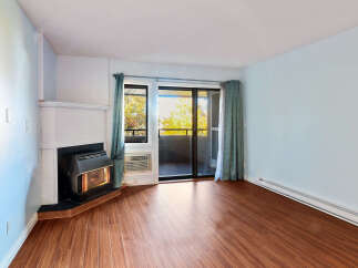 Cozy living room featuring a fireplace and a sliding glass door leading to a balcony.