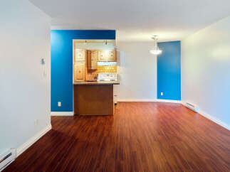 Step into this inviting living space featuring a modern open-concept layout with rich hardwood flooring throughout.