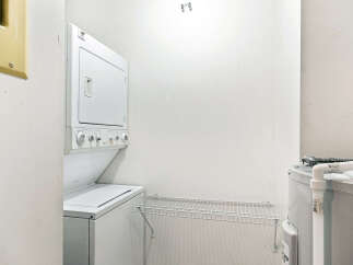 This laundry area features a stacked washer and dryer unit, perfect for maximizing space in your home.