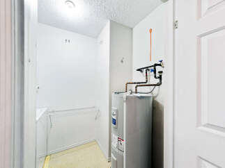 Discover this functional laundry room, complete with a large water heater and ample storage space.