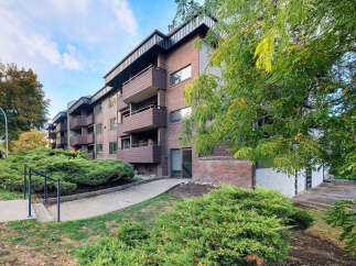 Discover this charming brick apartment building featuring multiple levels with private balconies, perfect for enjoying the outdoors.