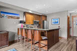 Experience modern living in this beautifully appointed kitchen, featuring rich wood cabinetry, a sleek granite countertop, and a convenient breakfast bar with comfortable seating.