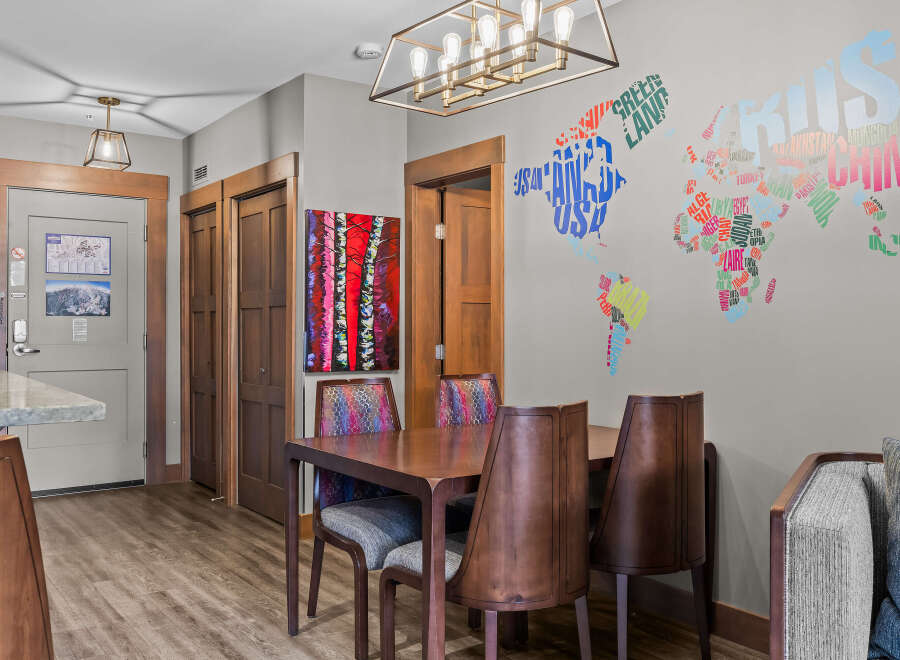 This dining area features a stylish wooden table with four chairs, each upholstered in a vibrant, patterned fabric.