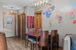 This dining area features a stylish wooden table with four chairs, each upholstered in a vibrant, patterned fabric.