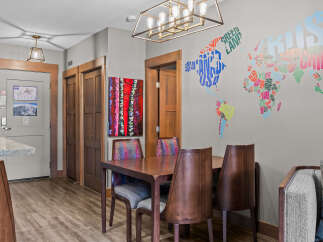 This dining area features a stylish wooden table with four chairs, each upholstered in a vibrant, patterned fabric.