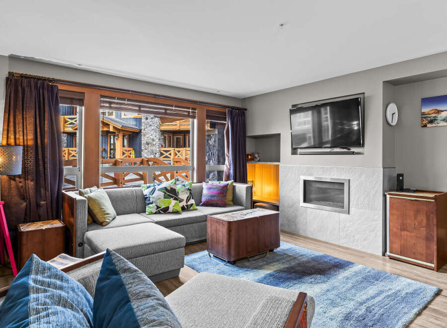 Step into this inviting living room, featuring a plush sectional sofa adorned with decorative pillows, perfect for cozy gatherings.