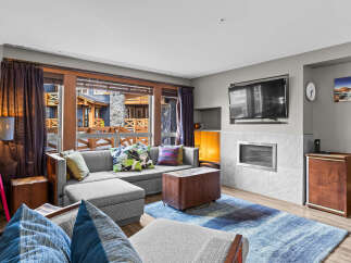 Step into this inviting living room, featuring a plush sectional sofa adorned with decorative pillows, perfect for cozy gatherings.