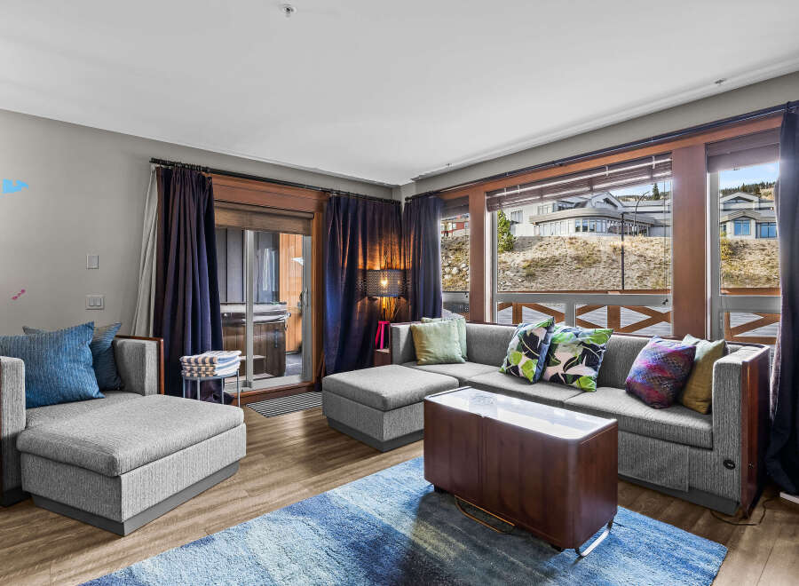 Experience ultimate relaxation in this luxurious living room, featuring a spacious sectional sofa and a comfortable armchair, perfect for unwinding.