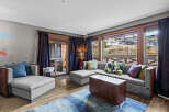 Experience ultimate relaxation in this luxurious living room, featuring a spacious sectional sofa and a comfortable armchair, perfect for unwinding.