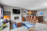 Experience modern living in this stylish open-concept condo, featuring a sleek fireplace and a large flat-screen TV for cozy evenings.