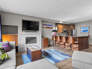 Experience modern living in this stylish open-concept condo, featuring a sleek fireplace and a large flat-screen TV for cozy evenings.