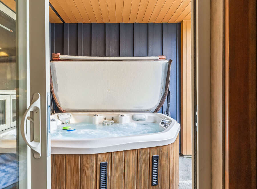 Indulge in ultimate relaxation with this luxurious hot tub, featuring a spacious design and bubbling jets for a spa-like experience.