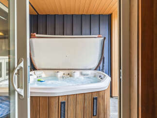 Indulge in ultimate relaxation with this luxurious hot tub, featuring a spacious design and bubbling jets for a spa-like experience.