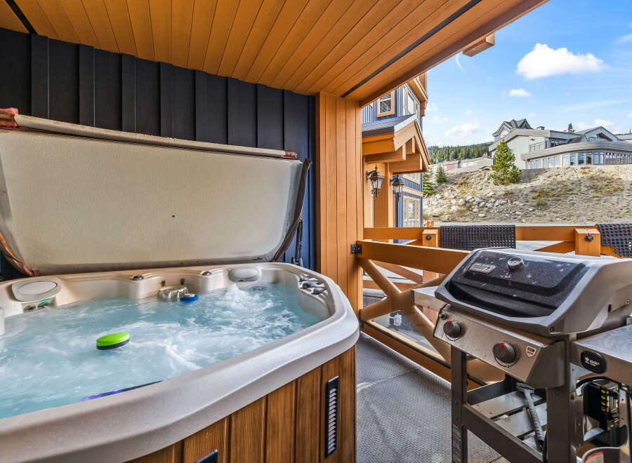 Enjoy ultimate relaxation and entertainment on this private balcony, featuring a bubbling hot tub perfect for unwinding after a day on the slopes.