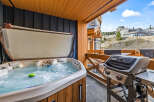 Enjoy ultimate relaxation and entertainment on this private balcony, featuring a bubbling hot tub perfect for unwinding after a day on the slopes.