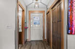 Step into this inviting hallway, featuring a modern light fixture and warm wood accents.