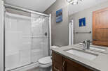 This modern bathroom features a sleek white shower stall with glass doors, complemented by a minimalist toilet and a floating vanity with a concrete countertop.