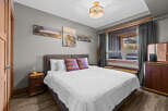 Experience comfort and style in this inviting bedroom, featuring a plush king-sized bed adorned with decorative pillows and crisp white linens.