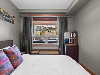 Experience comfort and style in this beautifully appointed bedroom, featuring a plush king-sized bed adorned with vibrant, decorative pillows.