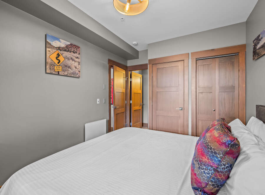 This bedroom features a comfortable bed with crisp white linens and a decorative accent pillow.