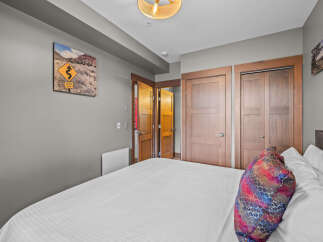 This bedroom features a comfortable bed with crisp white linens and a decorative accent pillow.