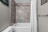 Experience modern comfort in this bathroom featuring a sleek bathtub and shower combination.