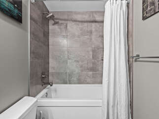 Experience modern comfort in this bathroom featuring a sleek bathtub and shower combination.