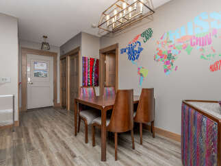 Step into a vibrant dining area featuring a stylish wooden table and chairs, perfect for family meals.