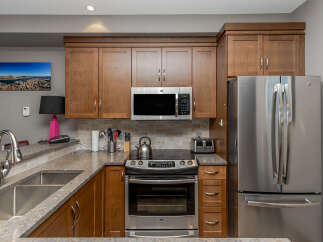 This modern kitchen boasts sleek stainless steel appliances, including a refrigerator, microwave, and oven, perfect for any home chef.
