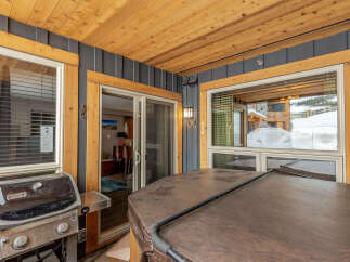 Enjoy outdoor living with this covered patio featuring a built-in hot tub and a Weber grill, perfect for entertaining.