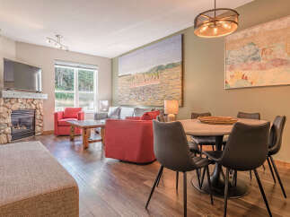 Experience cozy living with a stone fireplace and a large TV, perfect for relaxing evenings.
