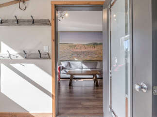 Step into a welcoming entryway featuring rustic wooden coat racks, perfect for storing outerwear.