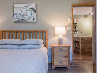 Experience comfort and convenience in this charming bedroom featuring a plush bed with crisp linens and a rustic wooden headboard.