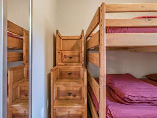 This charming bedroom features a sturdy wooden bunk bed, perfect for maximizing space and accommodating guests.