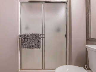Step into a clean and modern bathroom featuring a sleek frosted glass shower door.