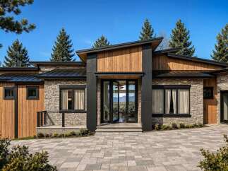 Experience modern luxury in this stunning home, featuring a striking architectural design with a blend of natural stone and warm wood accents.