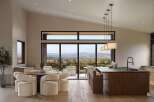 Experience modern luxury in this open-concept living space, featuring a gourmet kitchen with a sleek island and bar seating, perfect for entertaining.