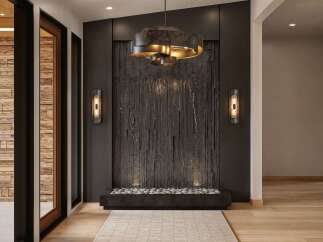 Step into a modern entryway featuring a striking dark wood waterfall feature, complemented by elegant wall sconces and a unique pendant light.