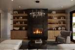 Experience modern luxury in this stunning living room, featuring a sleek fireplace as the centerpiece, flanked by elegant built-in shelving.