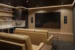 Experience cinematic luxury in this modern home theater, featuring plush leather seating and a large screen for an immersive viewing experience.