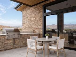 Experience luxury outdoor living with this stunning patio featuring a built-in grill and spacious countertop.