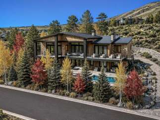 Experience luxury mountain living in this stunning contemporary home, nestled amidst vibrant autumn foliage.